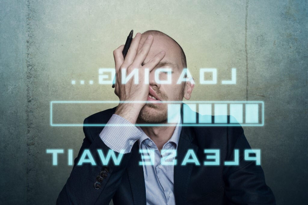 businessman or office worker waits bored and long on his slow computer or internet connection, displaying a loading bar and a messag