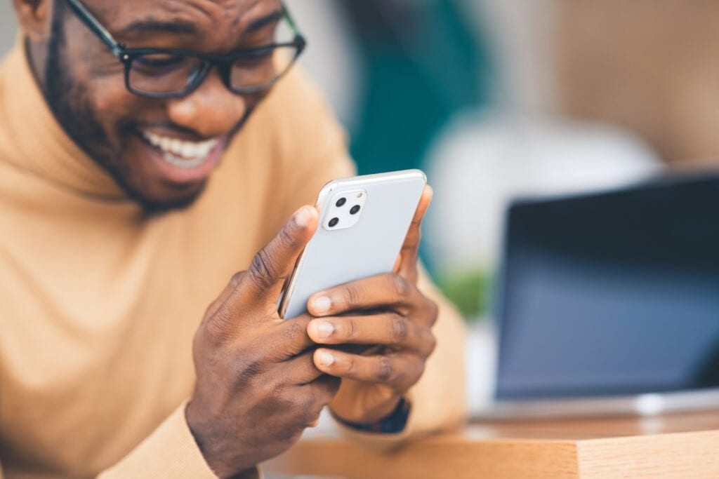 African-American man holding the latest Iphone 11 Pro Max model in silver color, close up