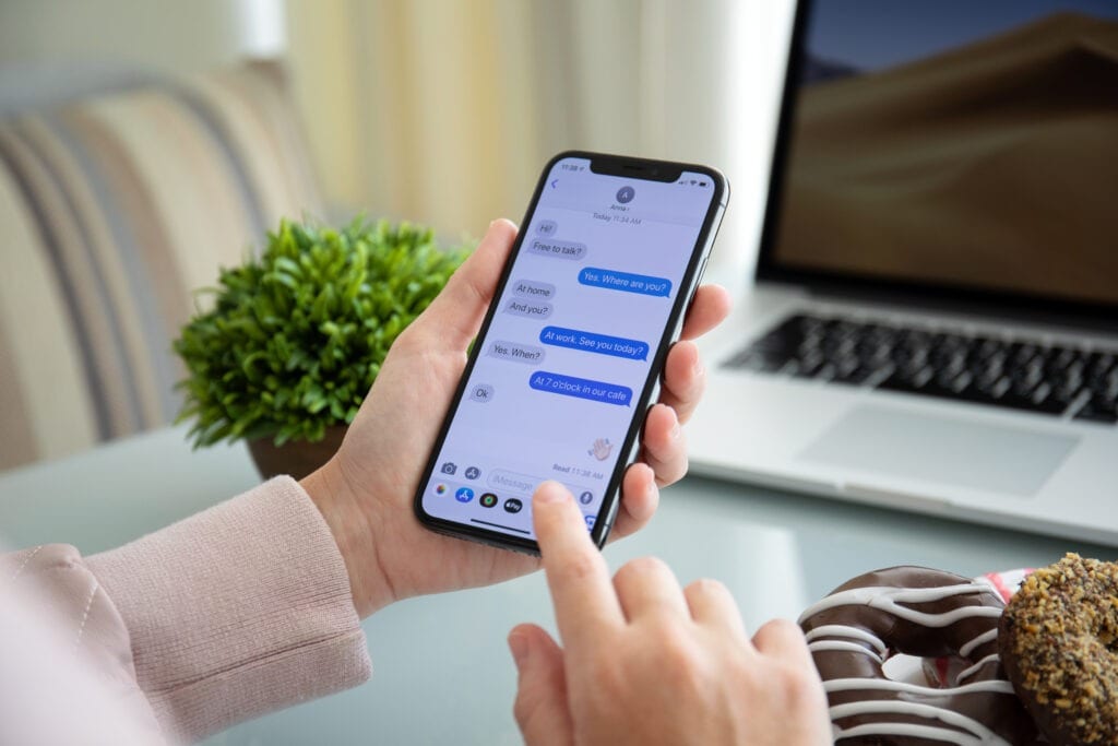 Alushta, Russia - September 28, 2018: Woman hand holding iPhone X with social networking service iMessage on the screen. iPhone ten was created and developed by the Apple inc.