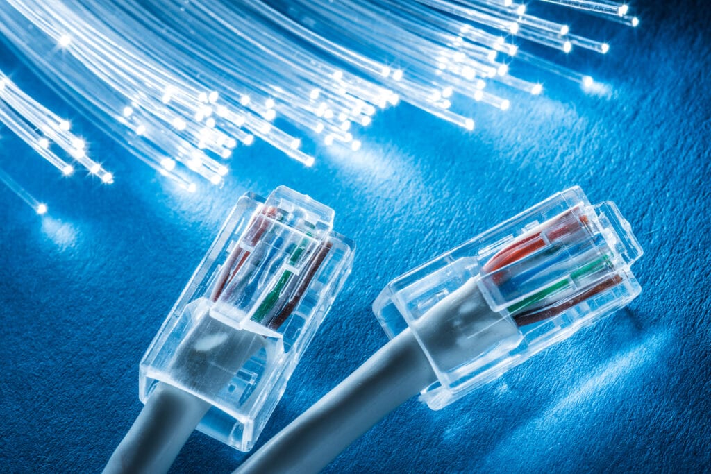 Network cables and optical fibers with lights in the ends at the background.